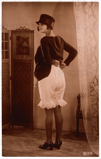 French Lingerie Model Lifting Dress to Reveal Bloomers, Rear View, 1915