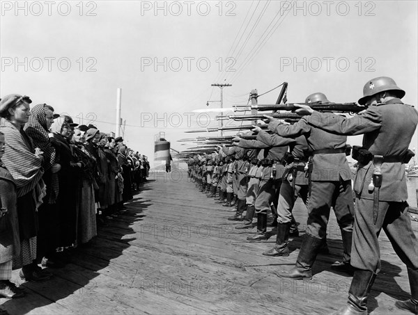 Row of German Soldiers with Rifles and Bayonets aimed at Norwegian Prisoners, on-set of the Film, "Edge of Darkness", 1943