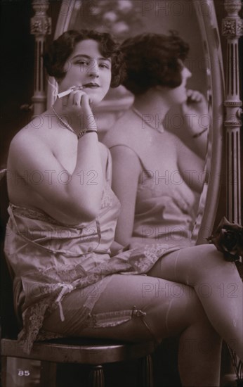 Lingerie Model Seated Beside Mirror Holding a Cigarette, circa 1920