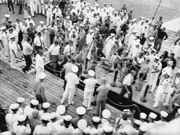 Astronauts Virgil "Gus" Grissom and John Young on Red Carpet on U.S.S. Intrepid on way to Debriefing after Completion of Gemini 3 Space Mission, 1965