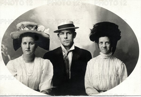 Two women Flanking Man, All in Hats, Portrait, circa 1909