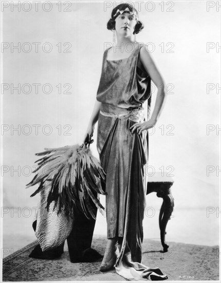 Fashionable Woman in Chiffon Velvet Dress Trimmed with Crystal and Headband Holding Feather Bouquet, Portrait, circa 1922