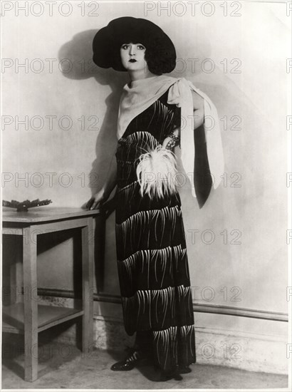 Fashionable Young Woman in Long Dress with Feather Pompom at Waist and Crepe Kerchief Tied Over Shoulder, with Hat, Portrait, circa 1922