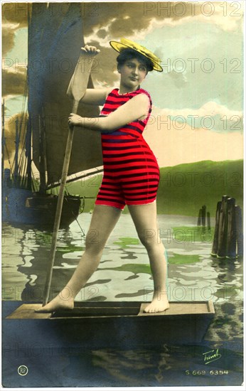 Woman in Red Striped Swimsuit Standing on Boat with Oar, Hand-Colored, Postcard, circa early 1900's