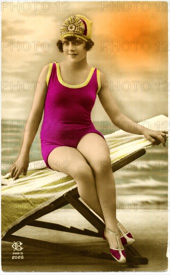 Woman in Purple Swimsuit and Swim Cap Sitting on Beach Chair, Hand-Colored  French Postcard, circa early 1900's