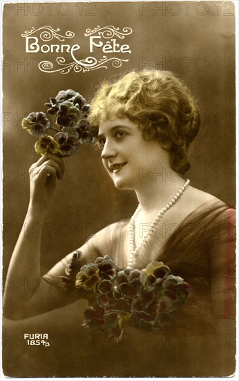 Smiling Woman Holding up Flowers while Holding Bouquet, "Bonne Fete", Hand-Colored, French Postcard, circa 1919