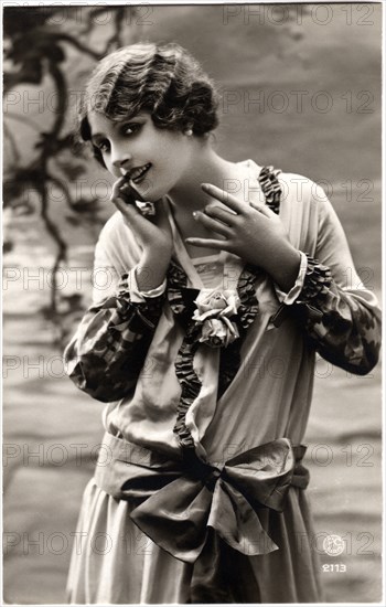 Smiling Woman with Wavy Hairstyle in Dress with Large Bow at Waist, Portrait, French Postcard, circa 1910's