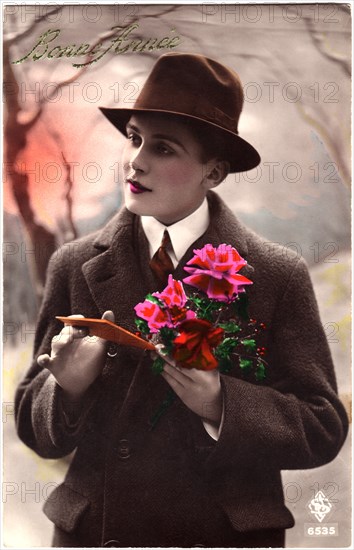Woman Dressed in Man' Coat and Hat Holding Flowers and Card, "Bonne France", Hand-Colored French Postcard, circa 1927