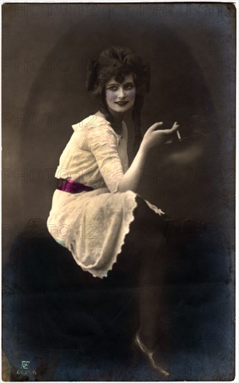 Seated Woman in White Dress and Red Sash Smoking Cigarette, Hand-Colored Postcard, Germany, circa 1920's