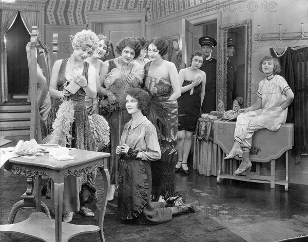 Mary Philbin, (kneeling), on-set of the Silent Film, "Fifth Avenue Models", 1925