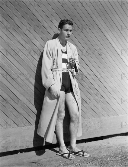 Actor Richard Arlen, Portrait in Two-piece Bathing suit and Flannel Robe with Reed-and-Leather Sandals, 1931