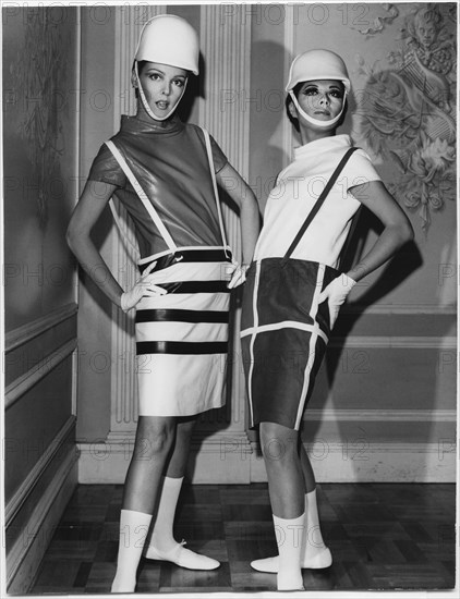 Two Fashion Models Wearing Sleek Interpretations of Andre Courreges’ Suspender Outfits Featuring Barrel Skirts with Button-Attached Suspenders and Leather Cowl-Neck Blouses, Presented by Samuel Robert, New York City, 1965