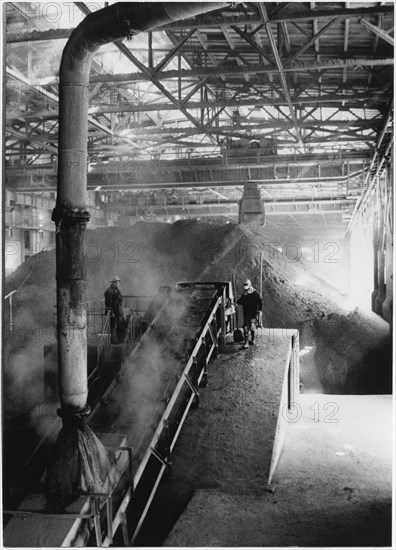 Dust Engulfing Workmen as Large Deposits of Phosphorous Fertilizer is Poured on to Conveyor Belts, Nanking Chemical Industrial Company, East China, 1965