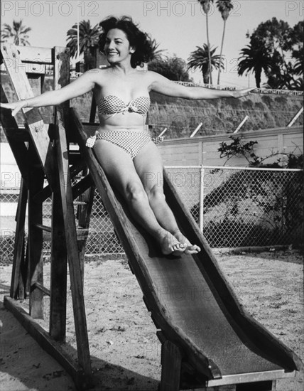 Actress Charlita, Publicity Portrait on Slide in Two-Piece Bathing Suit, circa 1955