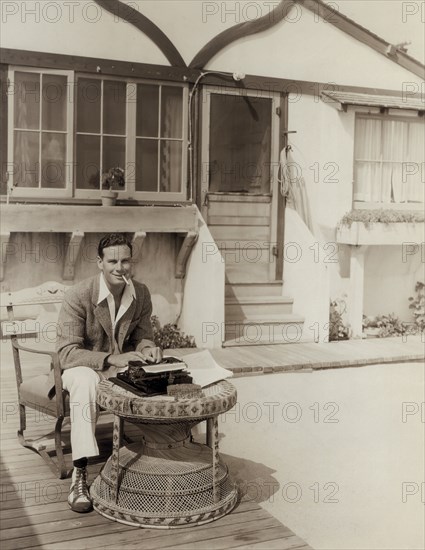 Norman Foster, Typing in front of his Beach Cottage, Publicity Portrait for the Film, "Orient Express", Fox Film Corp., 1934