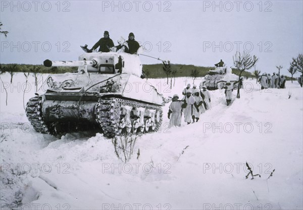 Camouflaged Tanks and Infantrymen Wearing Snow Capes Move Across Snow-Covered Field, Ardennes-Alsace Campaign, Battle of the Bulge, 1945