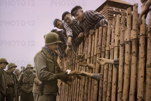 Enlisted Man of Seventh US Army Giving Cigarettes to Liberated Prisoners, Dachau, Germany, Central Europe Campaign, Western Allied Invasion of Germany, April 29,1945