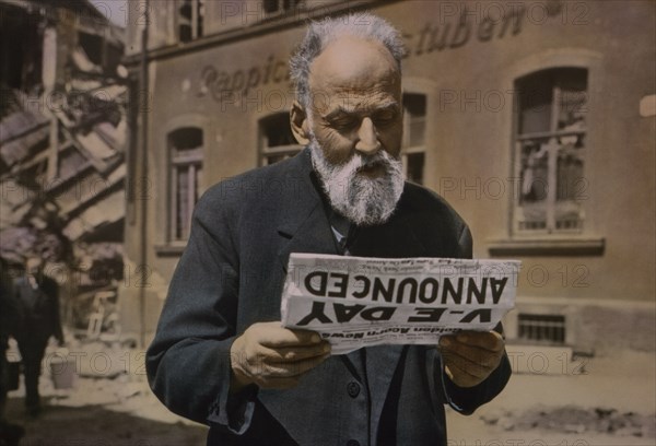 German Civilian Reading of Surrender of German Forces in Division Newspaper, Central Europe Campaign, Western Allied Invasion of Germany, May 1945