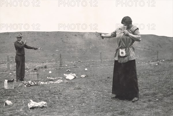 Mrs. Topperwein Demonstrating Marksmanship using Mirror to Shoot at Target held by her Husband on Outing, Idaho, USA, Otto M. Jones, 1915