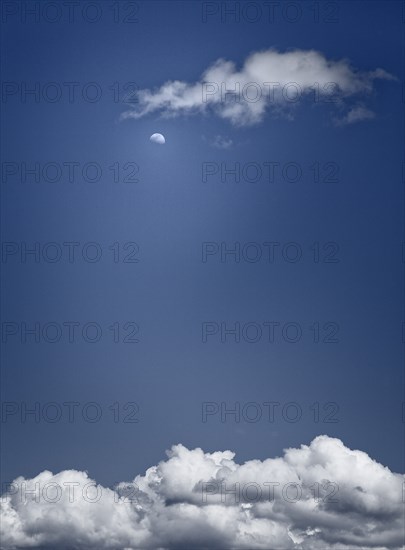 Moon and Clouds Against Blue Sky