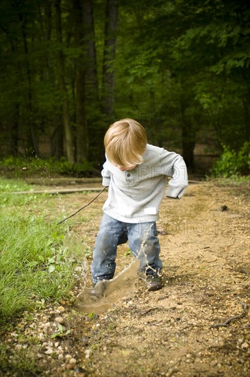 Boy Splashing in Puddle