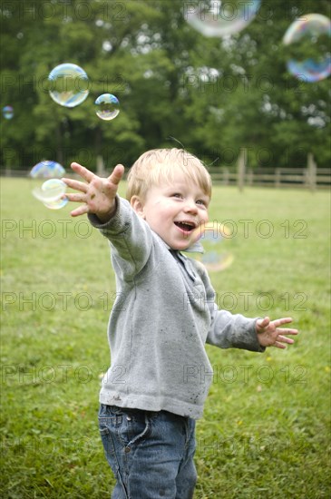 Happy Boy and Bubbles in Field