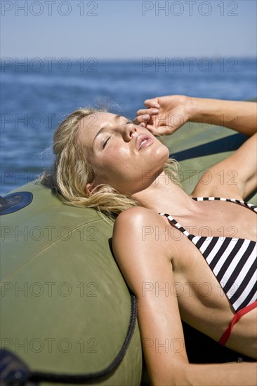Young Woman Sunbathing in Dinghy