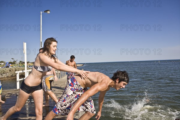 Woman Pushing Man into Water From Pier