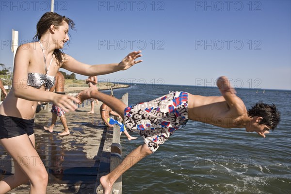 Young Woman Pushing Young Man into Water