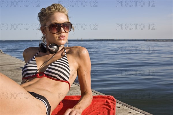 Young Woman Sunbathing on Pier