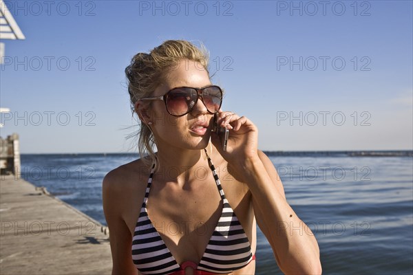 Young Woman Talking on Cell Phone on Pier