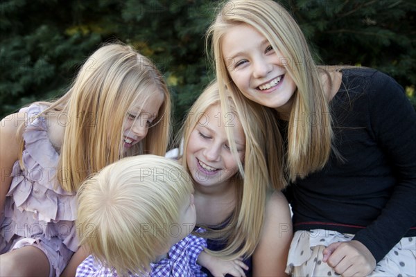 Smiling Girls Looking at Young Boy