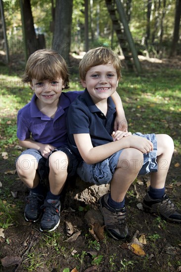 Two Smiling Boys Sitting on Rock