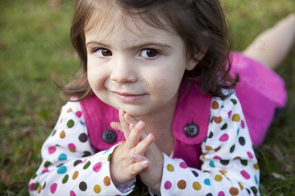 Young Girl Laying on Grass and Looking to Side, Portrait