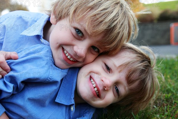 Smiling Boys Laying on Grass, Close-Up