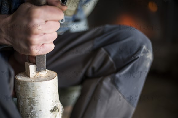 Hand of Woodworker using Chisel on Piece of Wood