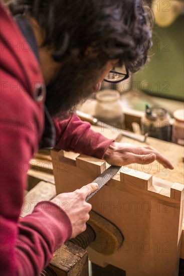 Woodworker Filing Dovetails in Piece of Wood, Close-Up