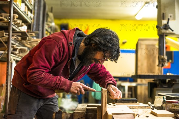 Woodworker Filing Dovetails in Piece of Wood