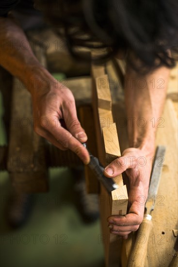 Woodworker Using Chisel on Piece of Wood, High Angle View