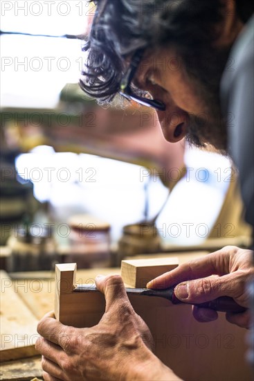 Woodworker Using Chisel on Piece of Wood, High Angle View