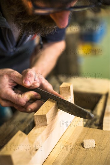Woodworker Using Rasp on Piece of Wood, High Angle View