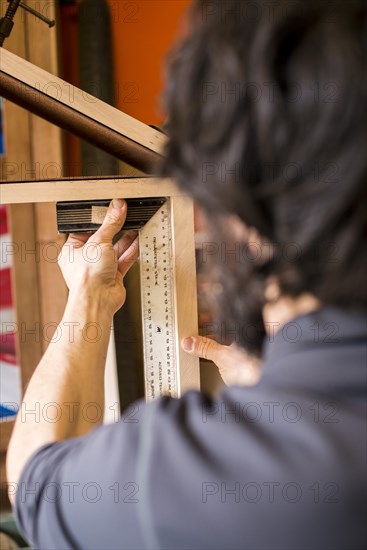 Woodworker Measuring a Shelf