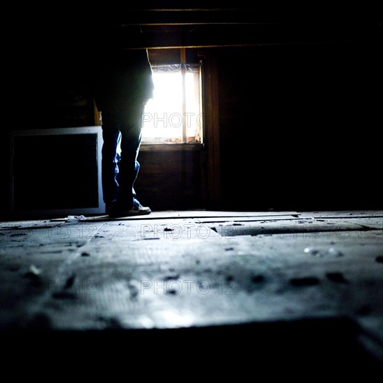 Person Standing in Empty Attic