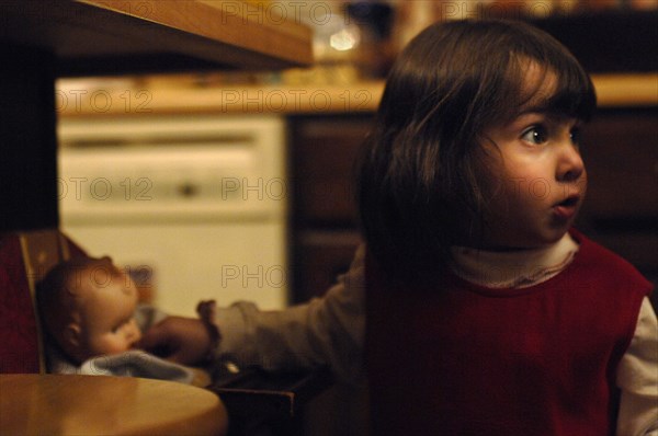 Little Girl with Baby Doll in Kitchen