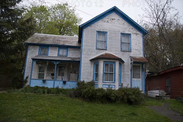 Rundown White House With Blue Trim