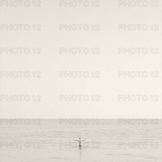 Man Standing in Ocean, Rear View