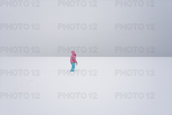 Lone Girl in Vast Snowy Field