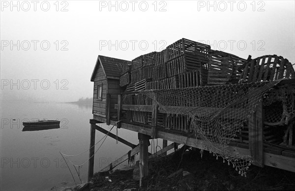 Pile of Lobster Crates Behind Shack on Dock, Maine, USA