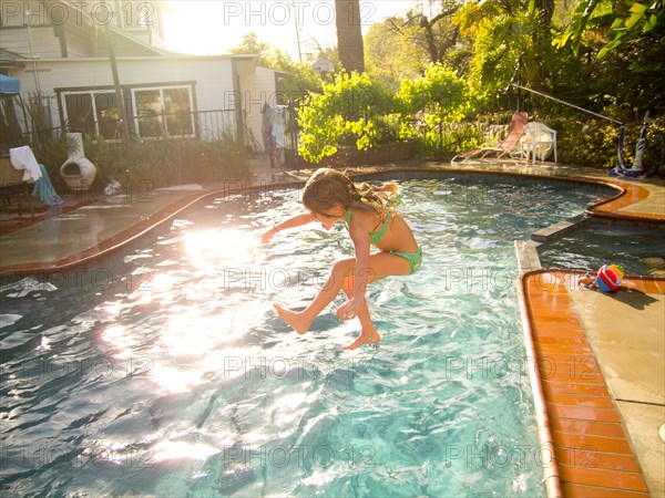 Young Girl Jumping in Pool