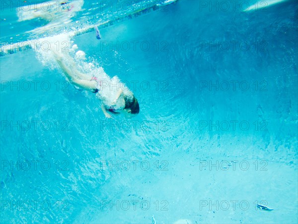 Girl Swimming Underwater after Pool Toy